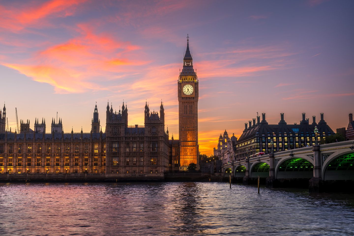 The Houses of Parliament, Big Ben and Westminster Bridge under a fiery sunset sky